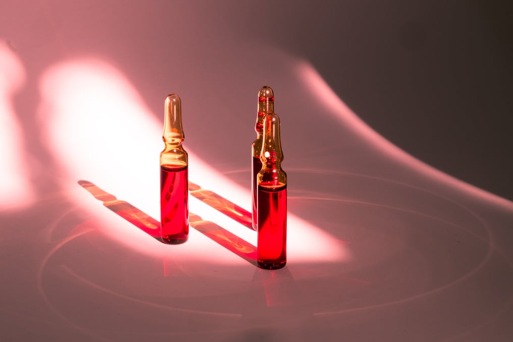 injections of B vitamins. Ampoules with red liquid. Beauty and health concept